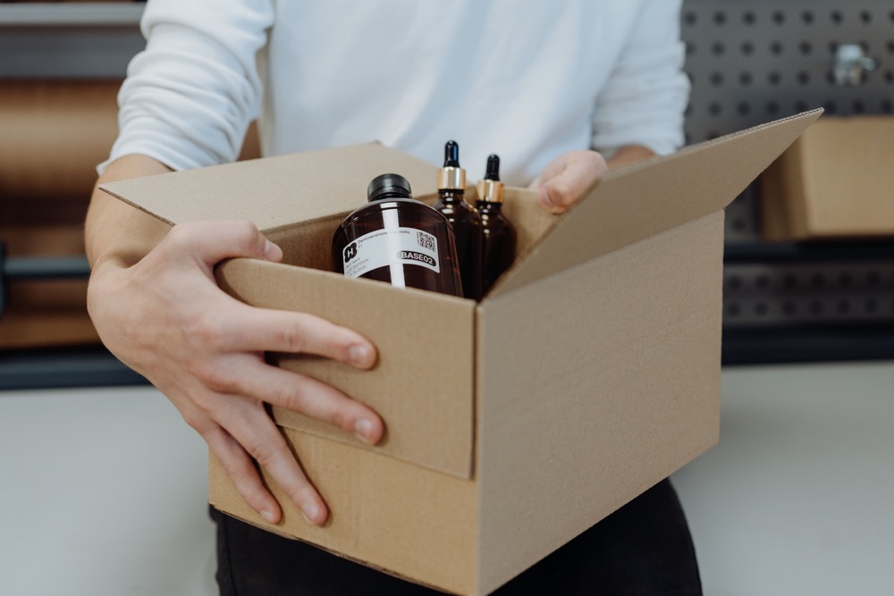 Préparation d’une commande — flacons de matières premières dans un carton